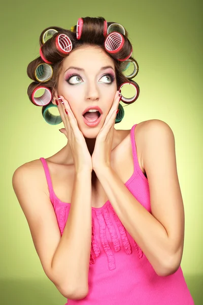 Beautiful girl in hair curlers on green background — Stock Photo, Image