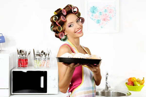 Bella ragazza in bigodini per capelli in cucina — Foto Stock