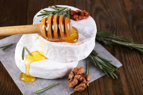 Queijo camembert, mel e nozes em guardanapo sobre fundo de madeira — Fotografia de Stock