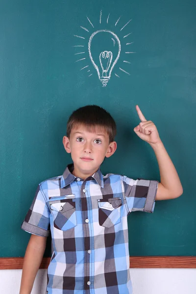 Schoolboy at blackboard in classroom Stock Image