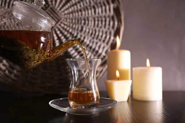 Tee in Glasschale auf dunklem Hintergrund gießen — Stockfoto