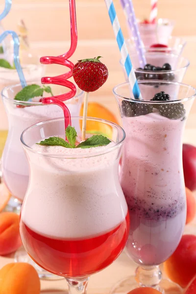 Deliciosos batidos na mesa de madeira, close-up — Fotografia de Stock