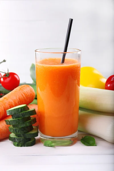 Verre de jus de carotte et légumes frais sur table en bois — Photo