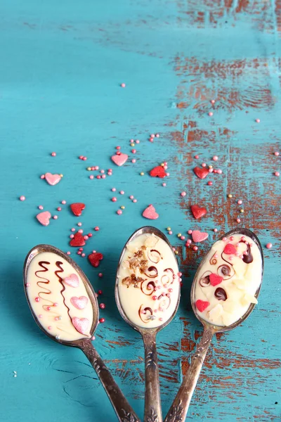 Spoons with tasty chocolate for party on old blue wooden table — Stock Photo, Image