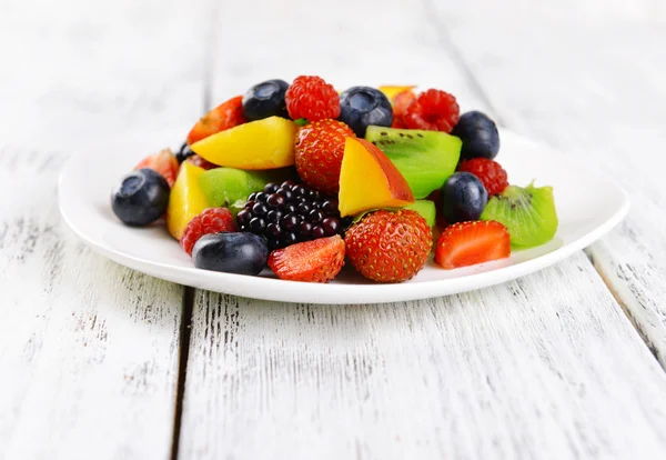 Deliciosa ensalada de frutas en plato en primer plano de mesa — Foto de Stock