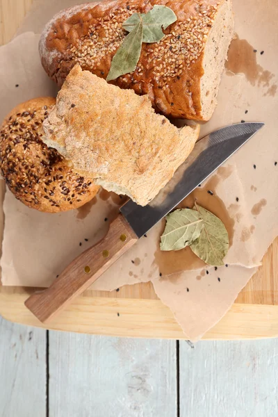 Vers gebakken brood, op snijplank, op houten achtergrond — Stockfoto