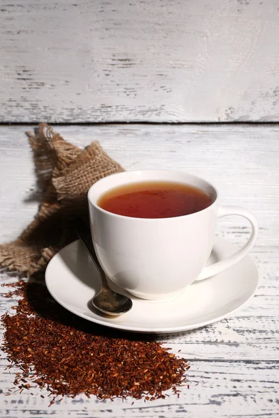 Чашка вкусного чая с ройбосом, на старом белом деревянном столе — стоковое фото