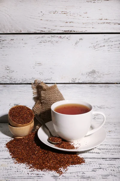 Cup of tasty rooibos tea, on old white wooden table — Stock Photo, Image