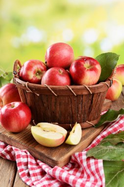 parlak zemin üzerine masada ahşap sepet içinde tatlı elma