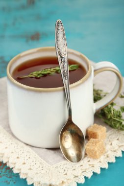 Mavi ahşap masada kekik ile lezzetli bitkisel çay