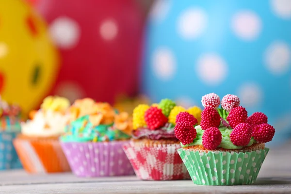 Deliciosos cupcakes de cumpleaños en la mesa sobre un fondo brillante —  Fotos de Stock