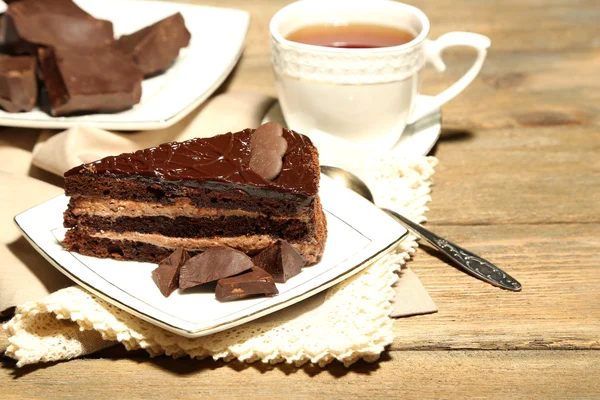 Шоколадний торт на тарілці, на дерев'яному фоні — стокове фото
