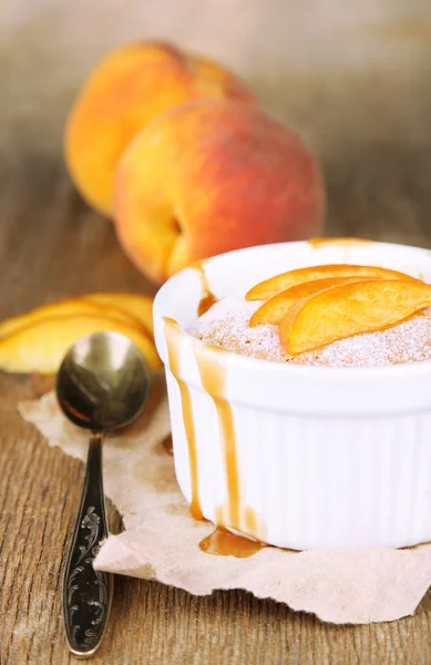 Tasty mini cake with fresh peach, on wooden table — Stock Photo, Image