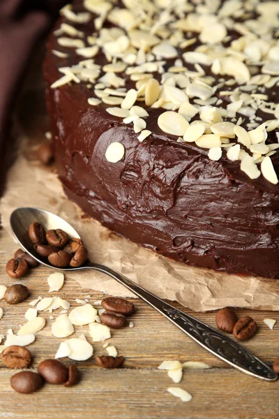 Tasty chocolate cake with almond, on wooden table — Stock Photo, Image