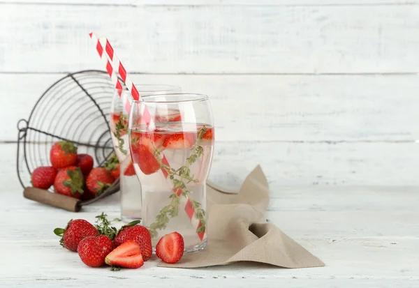 Tasty cool beverage with strawberries and thyme, on wooden background — Stock Photo, Image