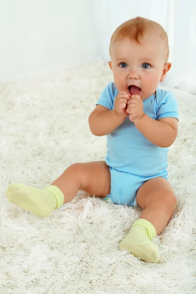 Schattige babyjongen op tapijt in kamer — Stockfoto