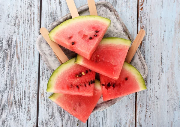 Slices of watermelon on tray on wooden background — Stock Photo, Image