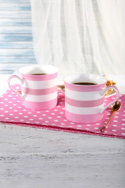Twee mokken koffie met koekjes op servet op tafel op witte gordijn achtergrond — Stockfoto
