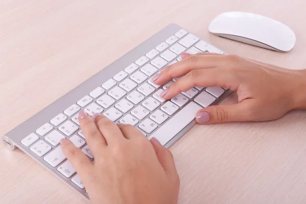 Vrouwelijke handen te typen op het toetsenbord op lichte achtergrond — Stockfoto