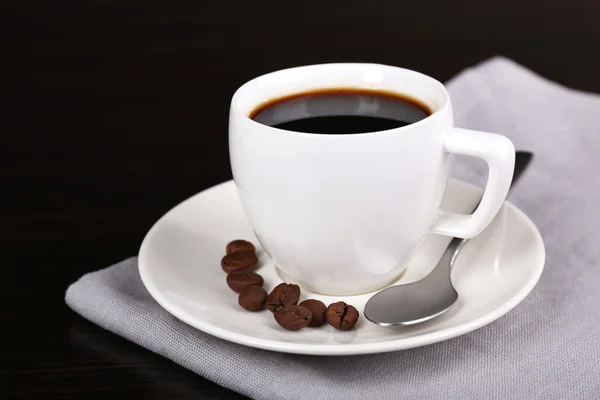 Filiżankę kawy a kawa w serwetkę na ciemnym tle — Zdjęcie stockowe