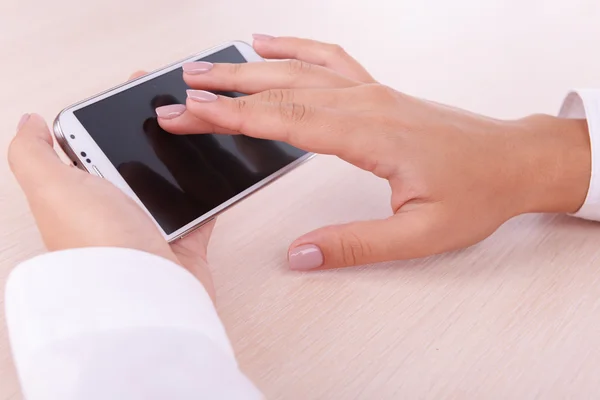 Frau benutzt Smartphone auf hellem Hintergrund — Stockfoto