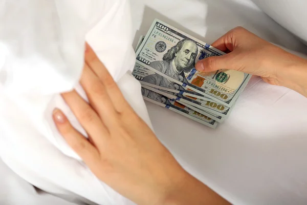 Woman hiding money under pillow at home — Stock Photo, Image