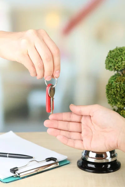 Female hand giving hotel key — Stock Photo, Image