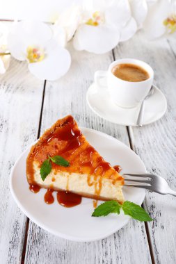 Peynir pasta, orkide ve ahşap zemin üzerine kahve