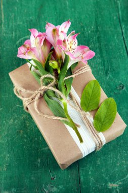 Taze çiçekler ve rustik sicim, ahşap arka plan üzerinde doğal tarzı el işi hediye kutusu