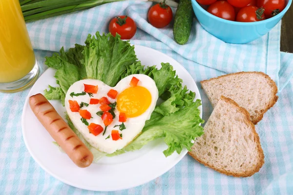 Œuf brouillé aux saucisses et légumes servi en assiette sur fond de tissu — Photo