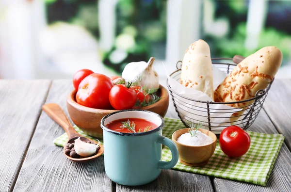 Jugo de tomate casero en taza de color, palitos de pan, especias y tomates frescos en la mesa de madera, en brillante —  Fotos de Stock