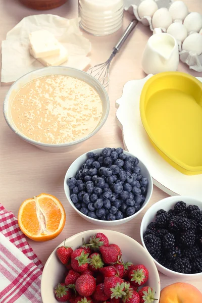 Hornear sabroso pastel e ingredientes para ello en la mesa en la cocina — Foto de Stock