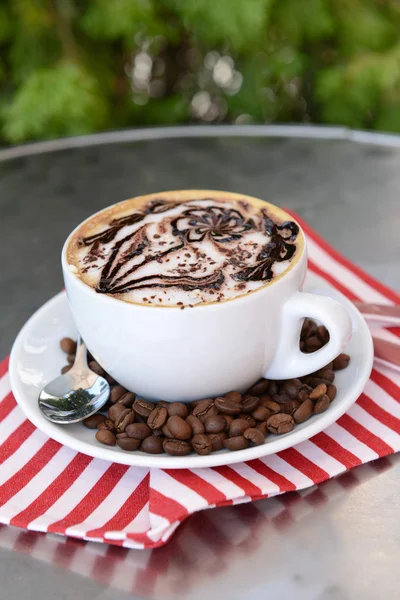 Kopje koffie met schattige puttend uit tabel, close-up — Stockfoto