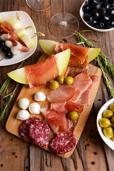 Delicious melon with prosciutto on table close-up — Stock Photo, Image