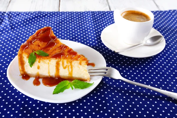 Bolo de queijo e xícara de café na toalha de mesa de bolinhas — Fotografia de Stock