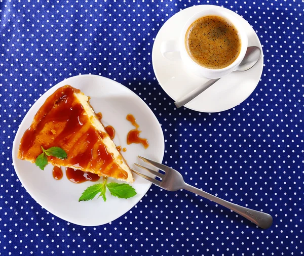 Torta di formaggio e tazza di caffè sulla tovaglia a pois — Foto Stock