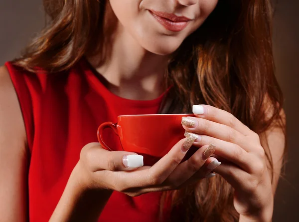 Hermosa joven con taza de café sobre fondo marrón — Foto de Stock