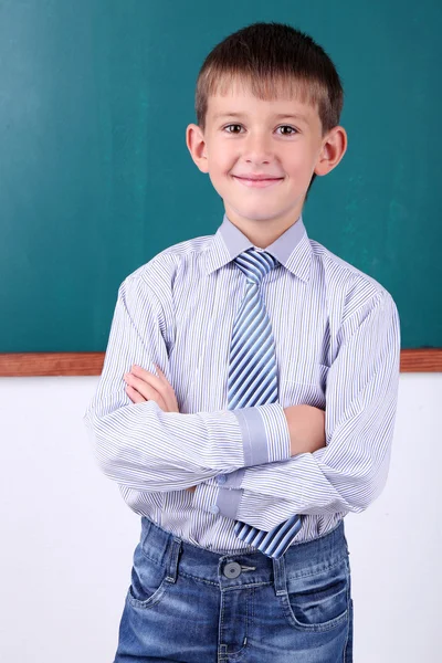 Schoolboy at blackboard in classroom — Stock Photo, Image