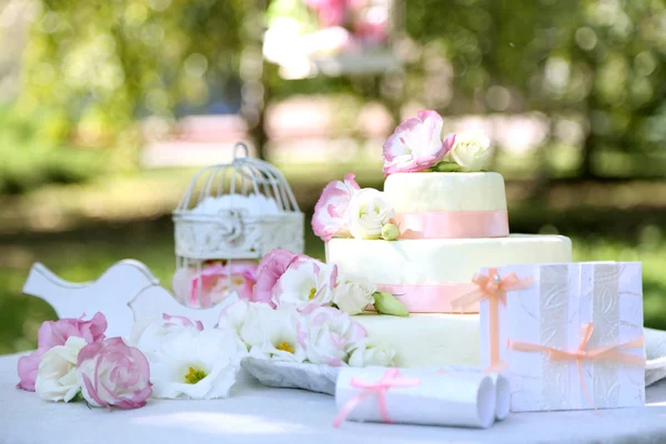 在桌子上，在户外花的美丽婚礼蛋糕。 — 图库照片