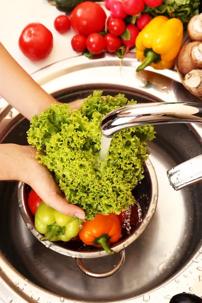 Tangan wanita mencuci sayuran di dapur — Stok Foto