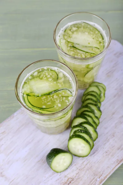 Glasses of cucumber cocktail on cutting board on wooden background — Stock Photo, Image