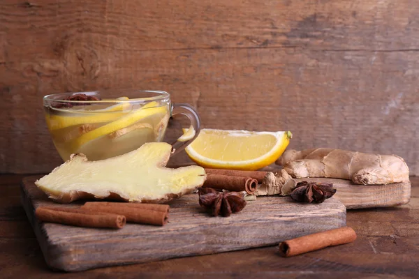 Beker van gember drank met citroen op snijplank op houten tafel op houten muur achtergrond — Stockfoto