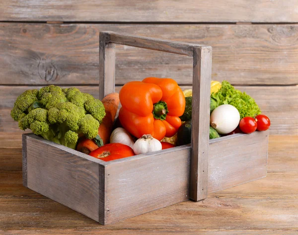 Fresh organic vegetables in wicker basket on wooden background — Stock Photo, Image