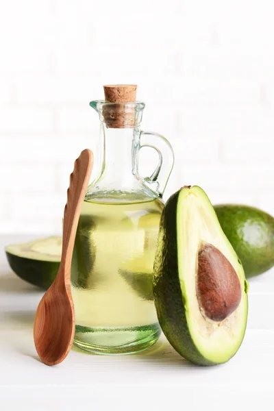 Avocado oil on table on light background — Stock Photo, Image