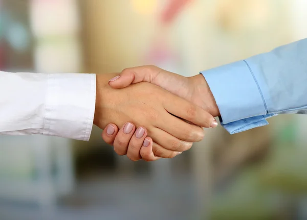 Geschäftlicher Händedruck vor hellem Hintergrund — Stockfoto