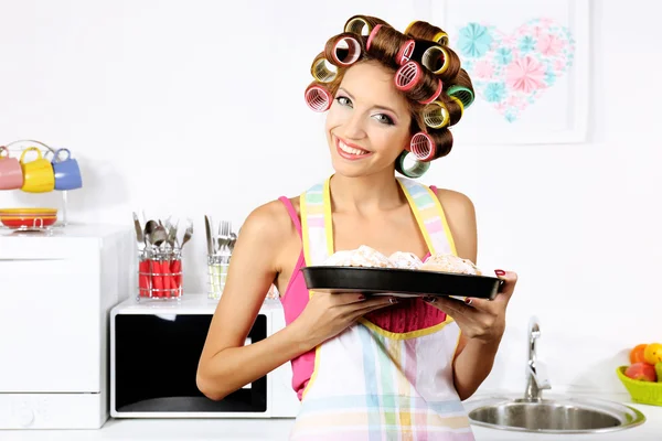 Bella ragazza in bigodini per capelli in cucina — Foto Stock