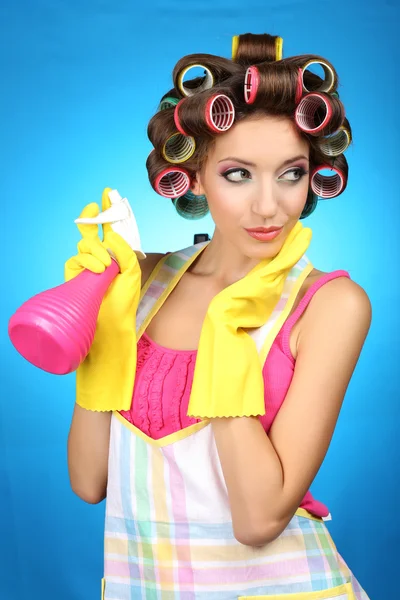 Bella ragazza in bigodini capelli su sfondo blu — Foto Stock