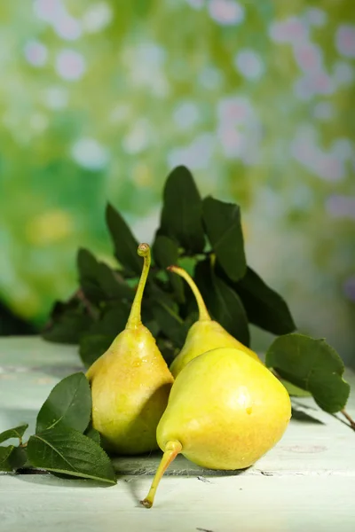 Ripe tasty pears on wooden table, on nature background — Stock Photo, Image