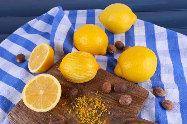 Lemons on cutting board on napkin on dark blue wooden background — Stock Photo, Image