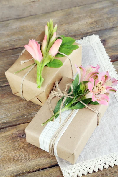 Přírodním stylu ručně dárkové krabičky s čerstvé rostliny a rustikální provázkem, na dřevěné — Stock fotografie